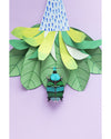 Gnome figure with a colorful hat and striped outfit on green leaf-like structures against a light purple background