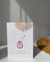 Greeting card with hedgehog illustration and balloons on a white surface.