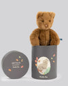 Brown teddy bear in a gray gift box with 'Arthur & Louison' branding on a light gray background