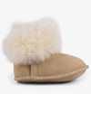 Tan baby bootie with white fur pom-pom on a white background