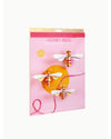 Packaging of honey bee decorations with a pink background and bee illustrations.