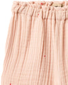 Close-up of pink textured fabric with a subtle pattern on a white background