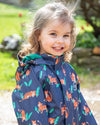 Child wearing a navy raincoat with orange tiger pattern outdoors