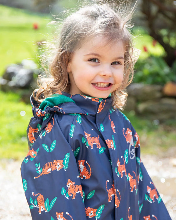 Child wearing a navy raincoat with orange tiger pattern outdoors