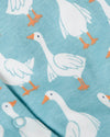 Pattern of white geese with orange feet on a light blue background