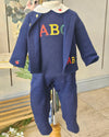 A navy blue baby outfit set consisting of a long-sleeve cardigan and matching pants, featuring colorful embroidered letters 'A', 'B', 'C' on the chest and a white collar with red heart details, displayed on a mannequin.