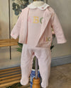 A baby girl's three-piece fleece outfit set in pale pink, displayed on a mannequin. The set includes a footed one-piece with 'ABC' lettering on the chest, a matching zip-up cardigan, and a white Peter Pan collar.