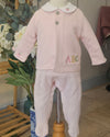 A baby's two-piece clothing set consisting of a light pink long-sleeve cardigan with a white Peter Pan collar and matching footed pants, displayed on a mannequin. The cardigan features three buttons, a small strawberry embroidery on the sleeve, and the letters 'ABC' embroidered in multicolor on the front.