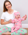 Woman holding a baby wearing pink outfits with strawberry pattern