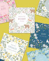 Collection of baby-themed cards with floral and nature designs on a yellow background.