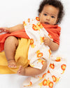 Baby wrapped in a floral blanket with a white background
