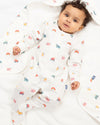 Baby in a white onesie with colorful patterns on a white background