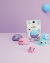 Colorful bath bombs with googly eyes on a purple background