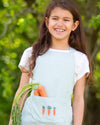 Young girl holding vegetables in a garden