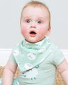 A baby wearing a mint green short-sleeve bodysuit and matching bib with a white sheep pattern, sitting against a light gray background.