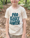 Child wearing a 'Pro Ruddle Jumper' t-shirt in a forest setting