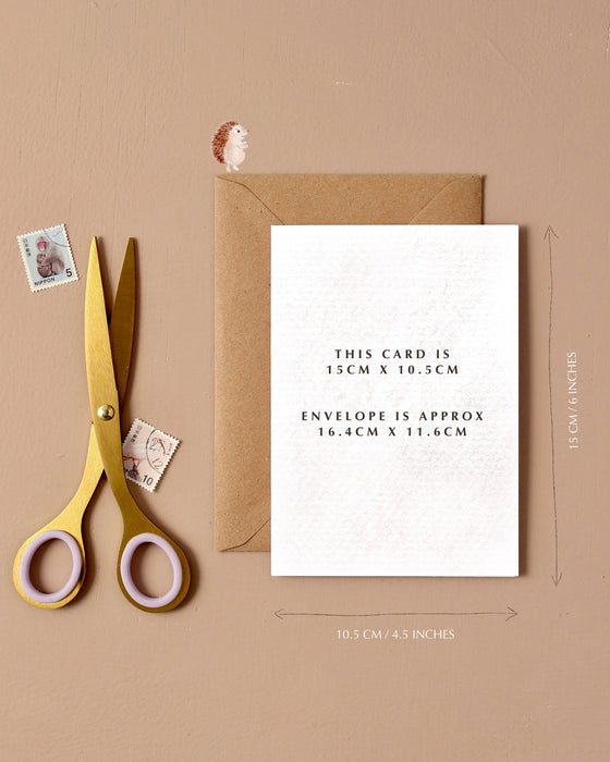 Greeting card with envelope and scissors on a beige background