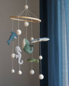 Decorative mobile with sea-themed hanging toys against a neutral background