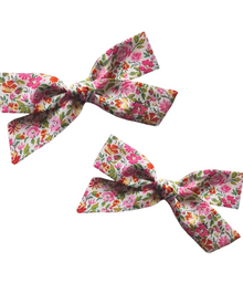  Two floral-patterned hair bows on a white background
