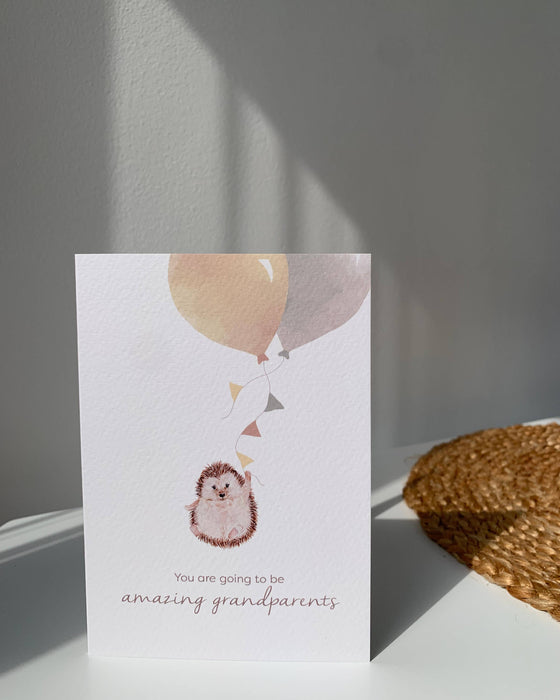 Greeting card with hedgehog illustration and balloons on a white surface.