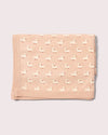 Folded pink blanket with duck pattern on a light gray background