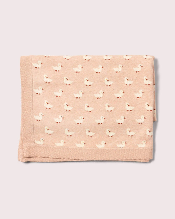 Folded pink blanket with duck pattern on a light gray background