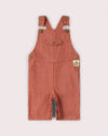 Red and white striped baby overalls on a light gray background