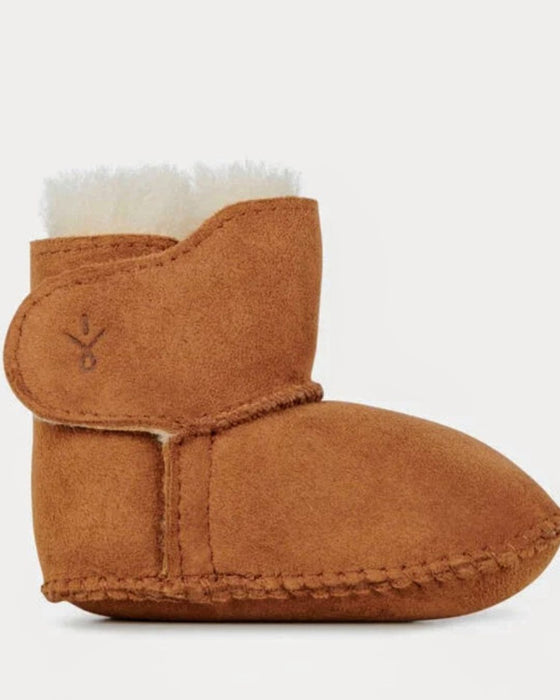 Brown baby bootie with white fur lining on a light gray background