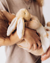 Child holding a plush bunny toy with a blurred background