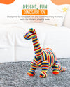 Colorful striped dinosaur toy on a carpeted floor with a white wall and decorative elements in the background.