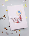 Card with a clown design and number 9 on a gray background with star confetti