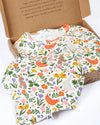 Floral and animal patterned fabric in a cardboard box with text on a white background
