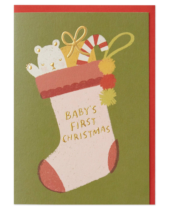 Christmas card with a stocking and baby's first Christmas text on a green background