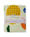Folded quilt with cartoon pineapple design and 'Halcyon Nights' branding on a white background