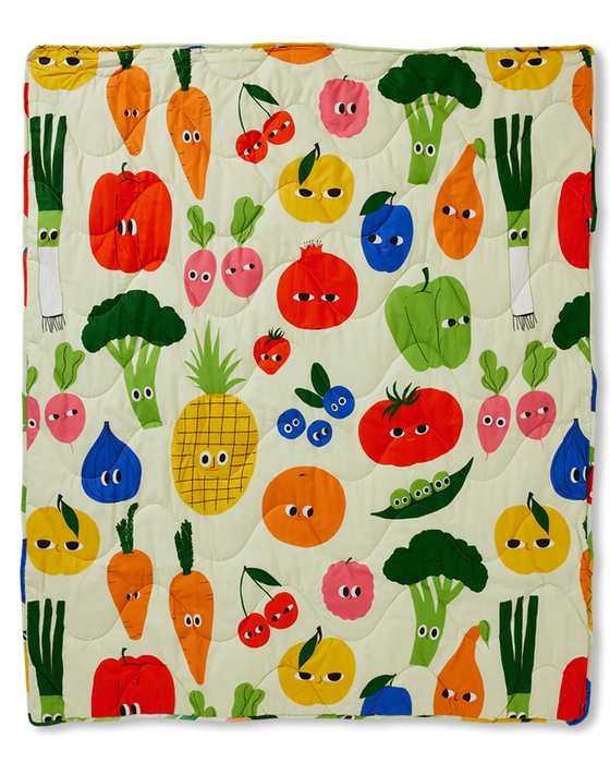 Quilt with colorful pattern of cartoon fruits and vegetables on a beige background