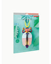 A 3D papercraft puzzle of a rhinoceros beetle, shown in its retail packaging. The packaging features a teal background with green leaf illustrations and a 3D model of the beetle in the center.