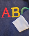 Navy blue fabric with colorful letters 'A', 'B', and 'C' embroidered on it.
