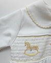 Close-up of a white garment with embroidered details on a light gray background