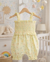 Yellow floral romper on a hanger in a nursery setting