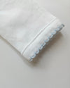 White fabric with light blue lace trim on a neutral background