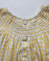 Yellow and white checkered dress with button details on a light gray background
