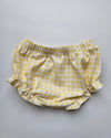 Yellow and white checkered baby bloomers on a gray background