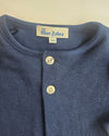 Close-up of a blue garment with 'The Blue Zebra' label on a beige background