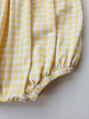 Yellow and white checkered fabric on a plain background